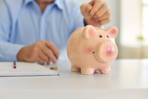 uomo che mette soldi in salvadanaio