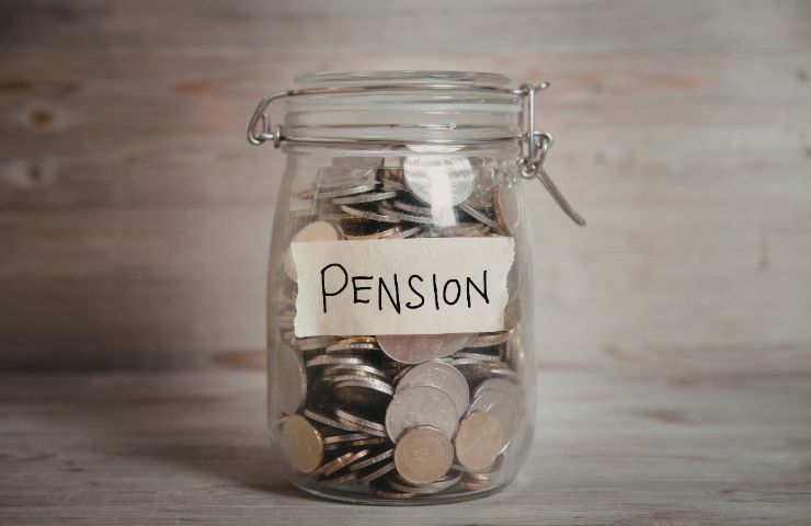 barattolo in vetro con spiccioli ed etichetta con scritto pensione