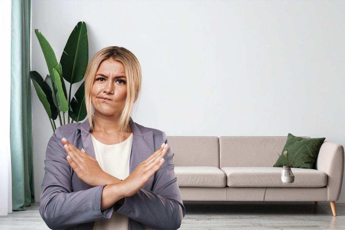 donna che dice no e divano posto davanti ad una parete